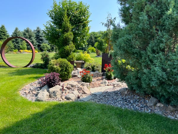Landscape Bed With Plants, Pathway, And Rock